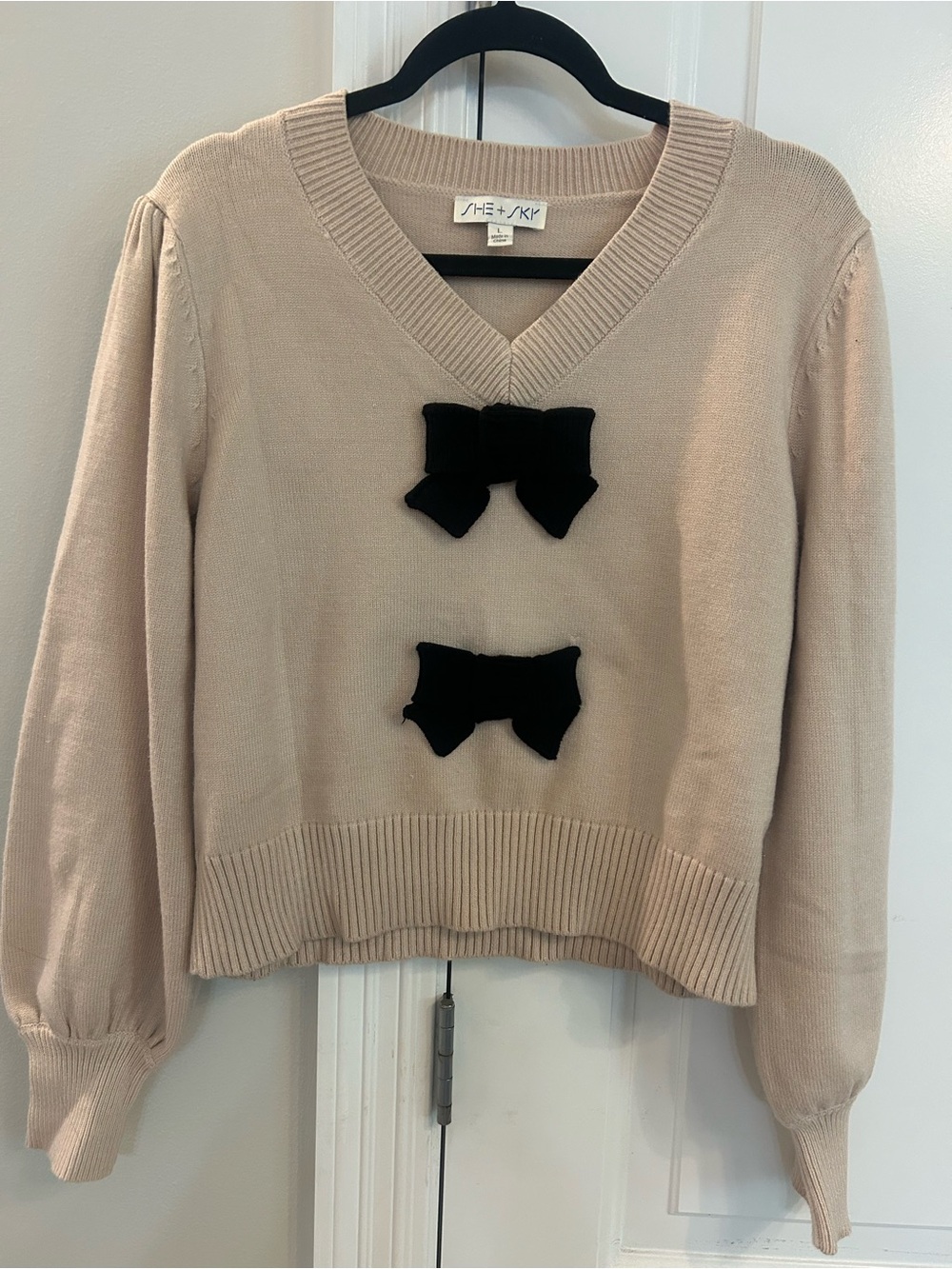 She + Sky Cream V-Neck Sweater with Black Bow Embellishments